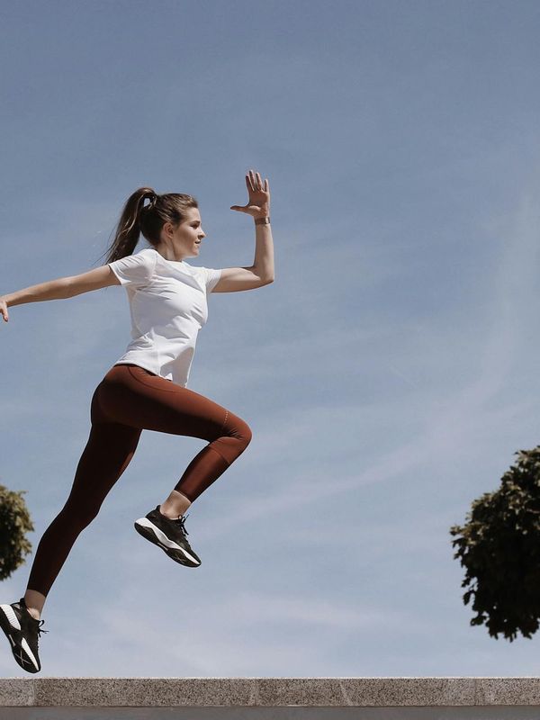 Person in a dynamic cardio stance, viewed from the side.